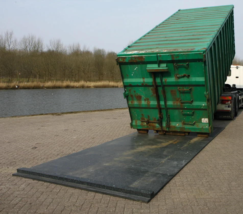 Containershield: Kunststoff-Schutzplatte unter einem abgesetzten Container auf einer Abstellfläche